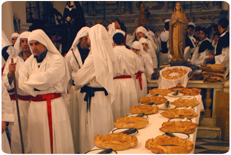 Cuglieri I Confratelli davanti alla tavola imbandita con i pani ed i pesci rituali, Settimana Santa a Cuglieri.